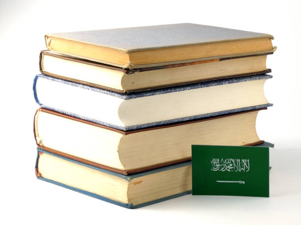 Saudi Arabian flag with pile of books isolated on white background stock photo