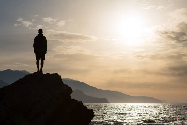 istock Hiking silhouette backpacker, man looking at ocean 843334876