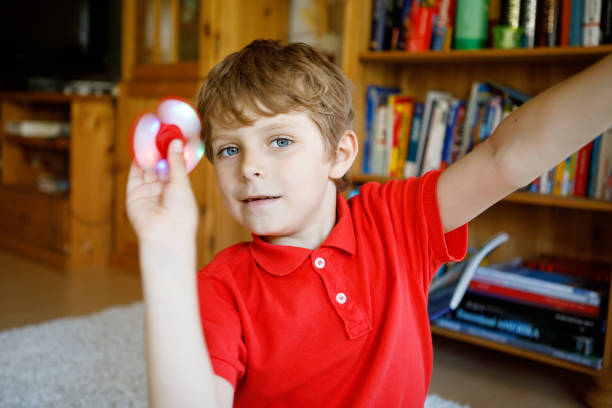 istock School kid playing with Tri Fidget Hand Spinner indoors 843334930