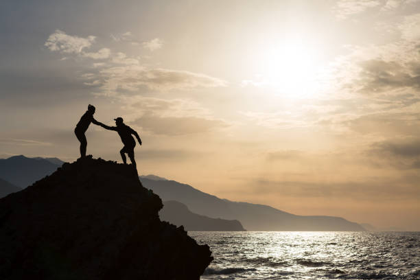 istock Teamwork couple climbing hiking with helping hand 843338000