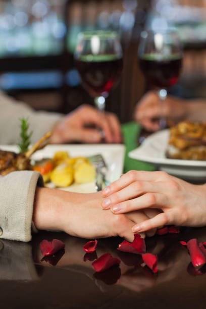istock Close up on couple holding hands during dinner 843338910