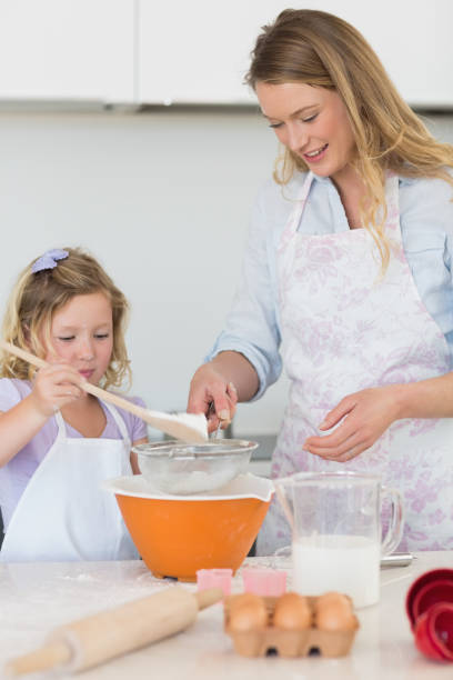 istock Mother teaching daughter to make cookies 843344920