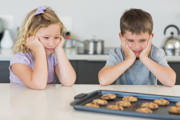 istock Brother and sister looking at tempting cookies 843345870