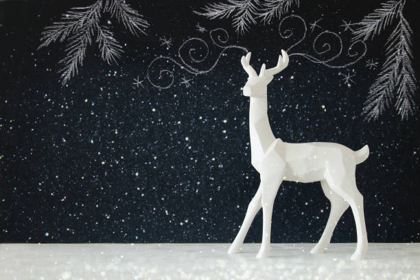 istock White reindeer on wooden table over chalkboard background with hand drawn chalk illustrations 843346014
