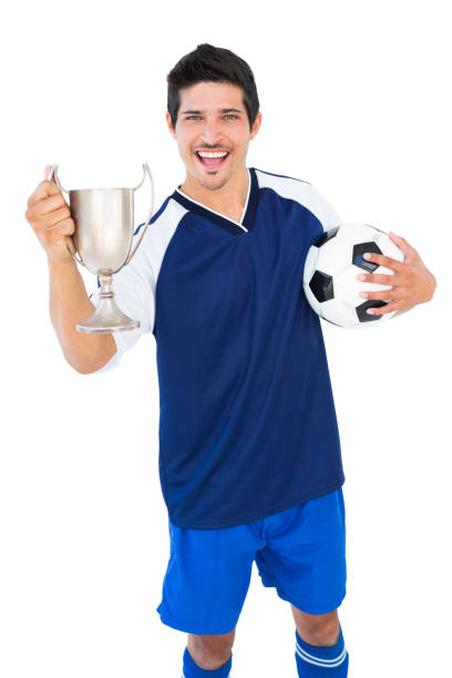 istock Football player in blue holding winners cup and ball 843349000