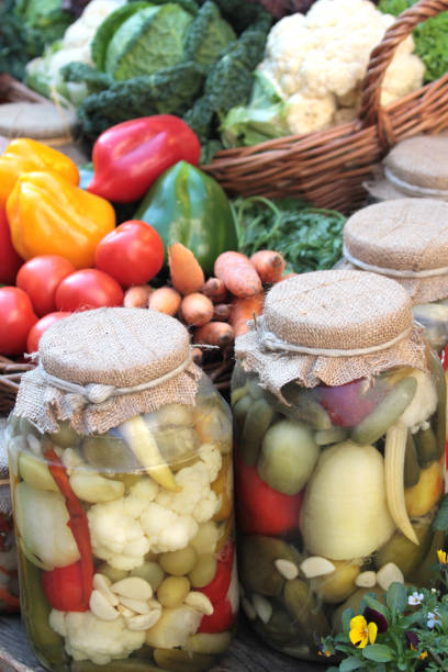 Fresh colorful vegetables and pickles in jars close up image