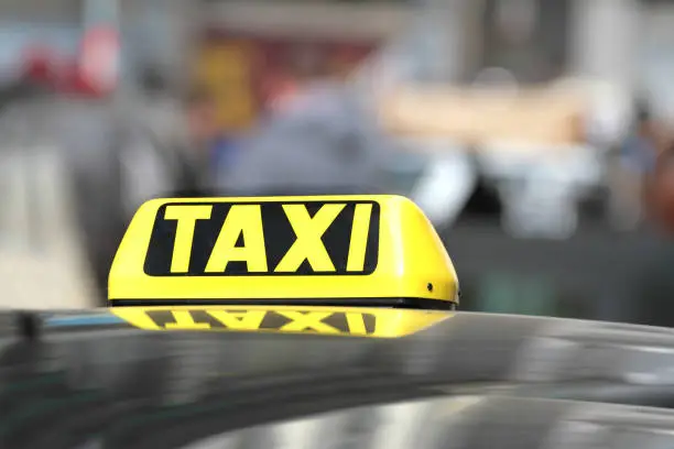 Photo of Black and yellow taxi sign.