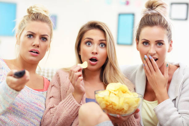 istock Three beautiful young women watching tv at home 843360456