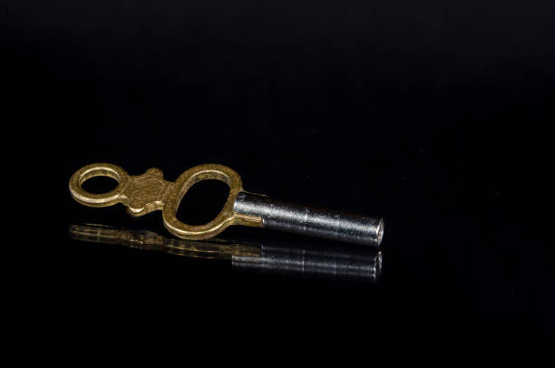 istock Antique Brass Pocket Watch Key Laying In The Darkness 843360962