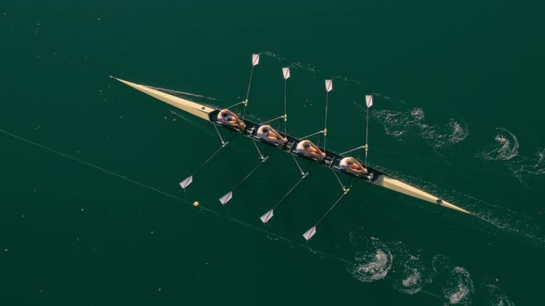 AERIAL Quad scull gliding across a lake on a sunny day