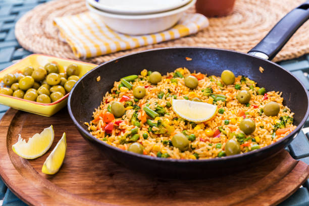 traditional spanish rice dish - vegetable paella - lemon food preparation portion imagens e fotografias de stock