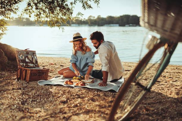 Perfect time together Couple in love enjoying picnic time and food outdoors. feeding grapes stock pictures, royalty-free photos & images