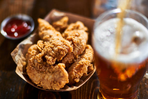 istock focus on fried chicken tenders in basket with beer 843380134