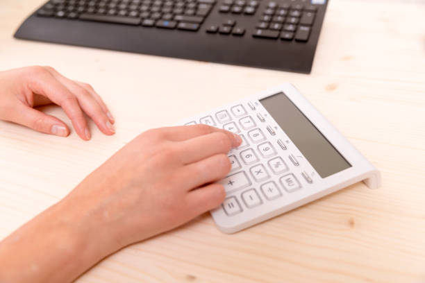 istock Accounting. Woman's hand pressing calculator buttons 843386290