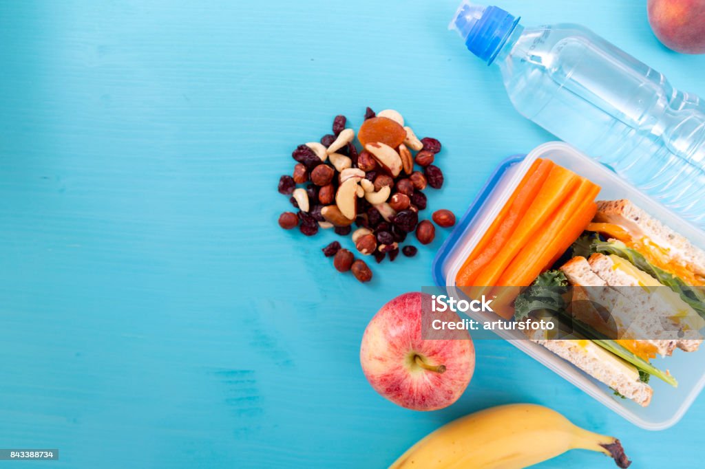Schule Lunchpaket mit Sandwich, Gemüse, Wasser, Nüssen und Früchten auf Türkis Hintergrund. Gesunde Ernährung Gewohnheiten-Konzept - Lizenzfrei Gesunder Lebensstil Stock-Foto