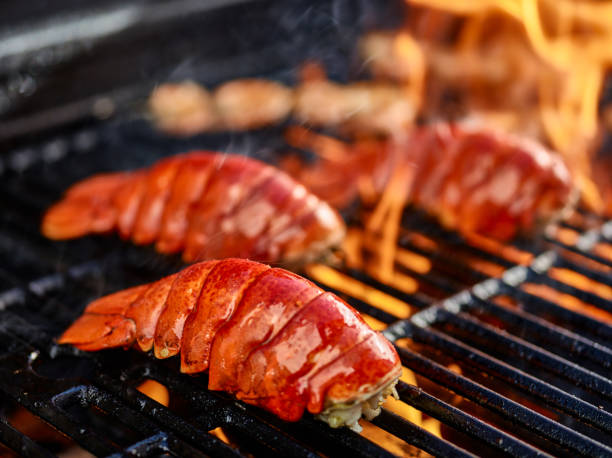 grilling lobster over hot flame grilling lobster tails over hot flame tail fin photos stock pictures, royalty-free photos & images