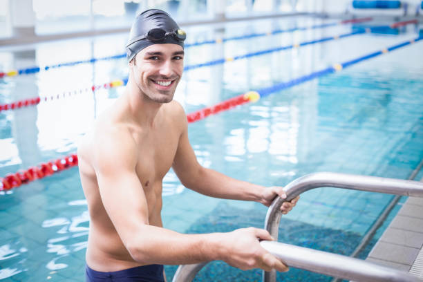 Handsome man getting out of the water at the pool