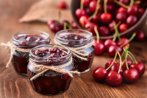 istock Cherry jam on wooden background in the jars 843394502