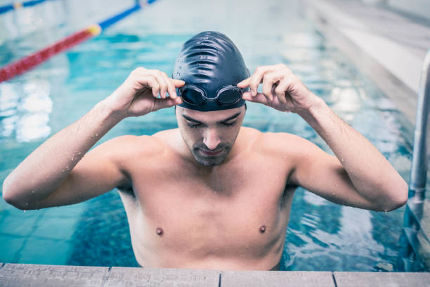 istock Handsome man wearing swim cap and goggles 843396904