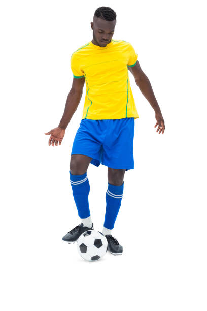 istock Football player in yellow kicking ball 843404342