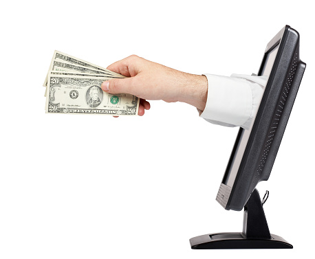 man hand giving dollars sticking out of monitor isolated on white