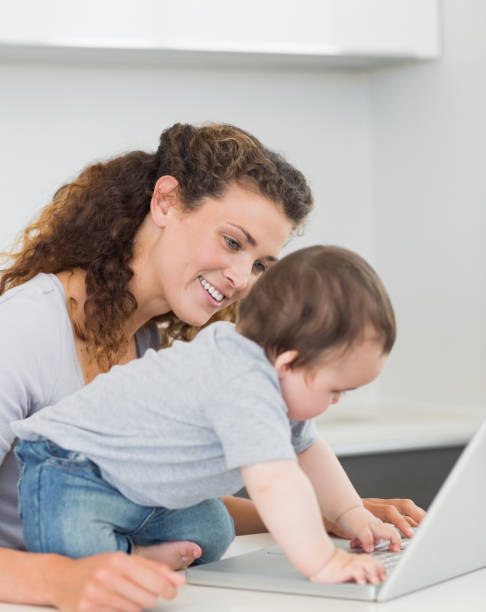 istock Mother looking at baby boy using laptop 843414632