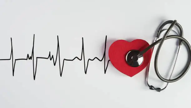 Photo of Medical stethoscope and red heart with cardiogram