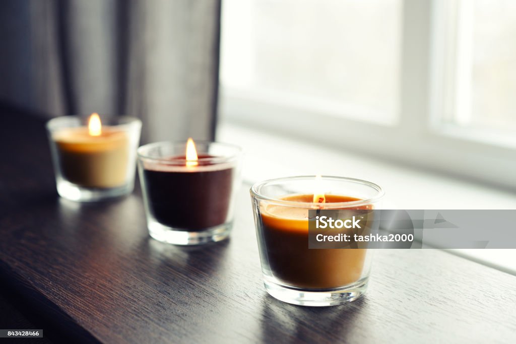 Cosy candles on an wooden table Cosy candles on an wooden table in home interior closeup Candle Stock Photo