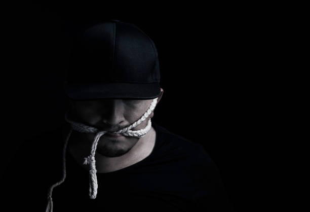 istock man with cap bite rope in front of black background 843439852