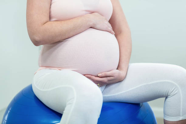 istock Pregnant woman sitting on exercise ball 843445714
