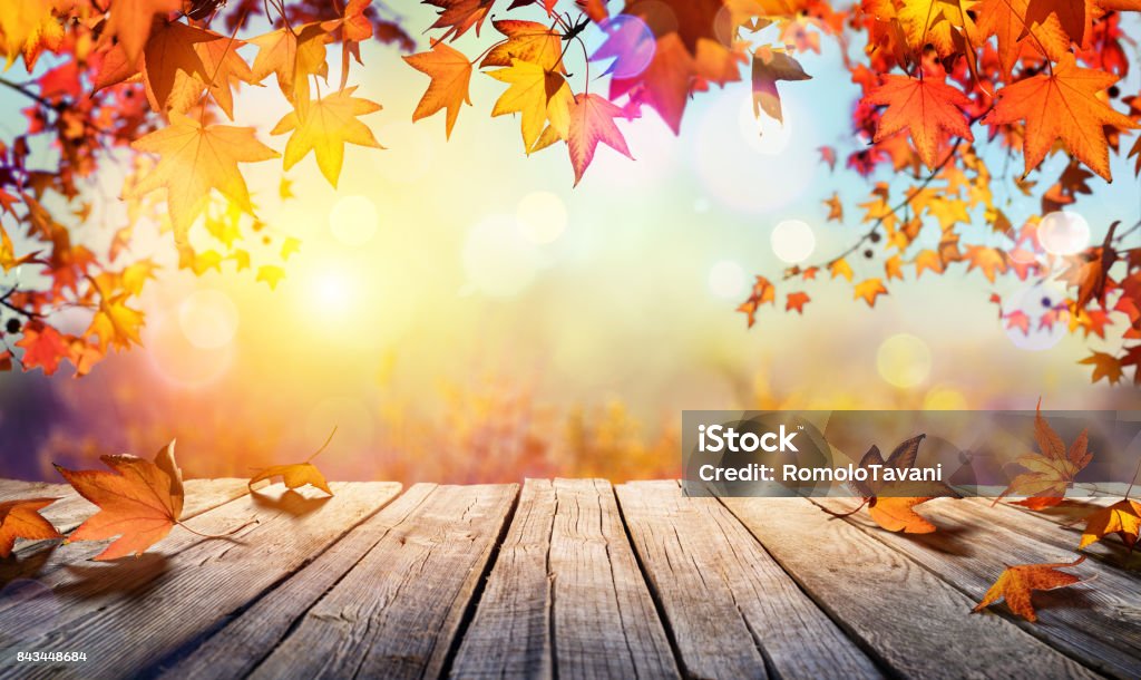 Mesa de madeira com folhas de laranja e fundo desfocado do outono - Foto de stock de Outono royalty-free