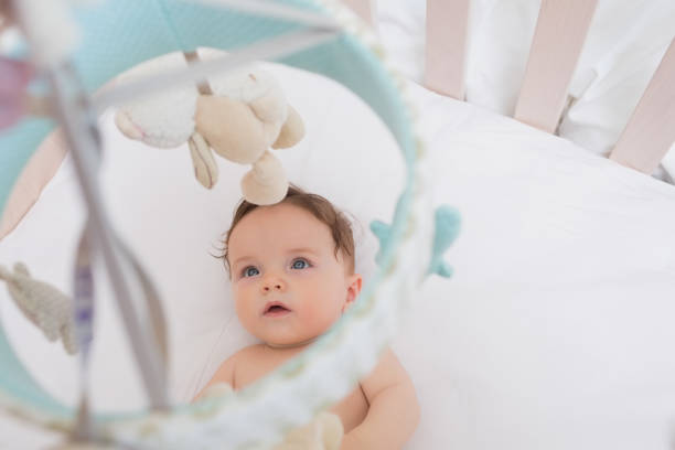 istock Baby looking at toys hanging in crib 843455178