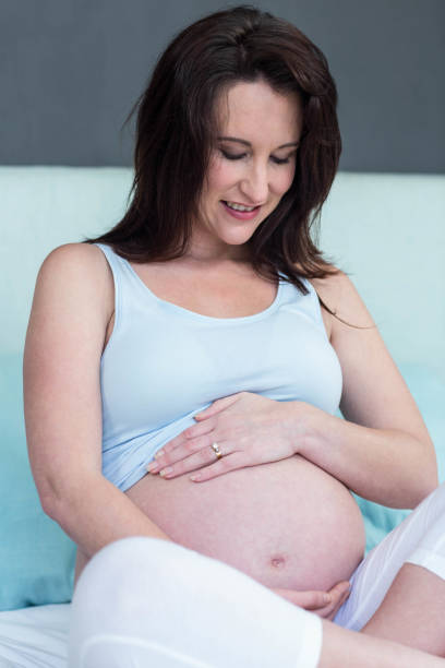 istock Pregnant woman sitting on bed 843458368