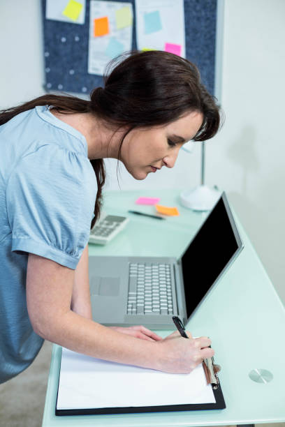 istock Pregnant woman writing on clipboard 843458826