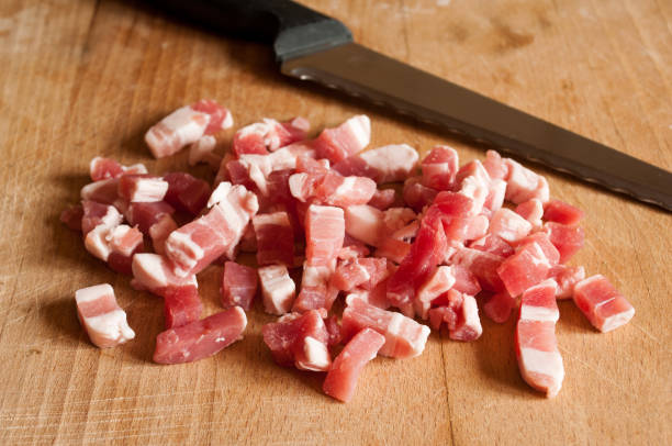 cubos de tocino en tablero de madera - pancetta fotografías e imágenes de stock