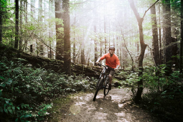 Mature Man Mountain Biking in Forest