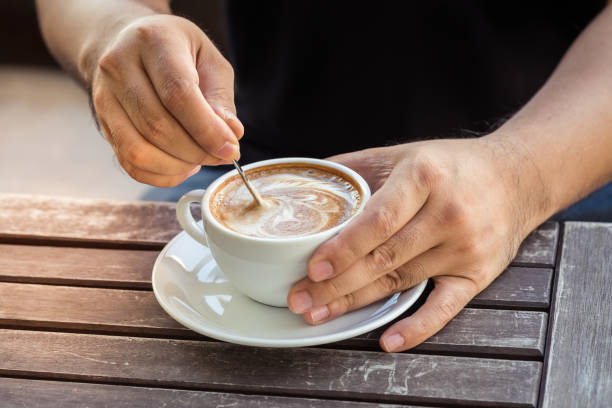 istock Man hand holding cup of coffee on old wooden table 843474116