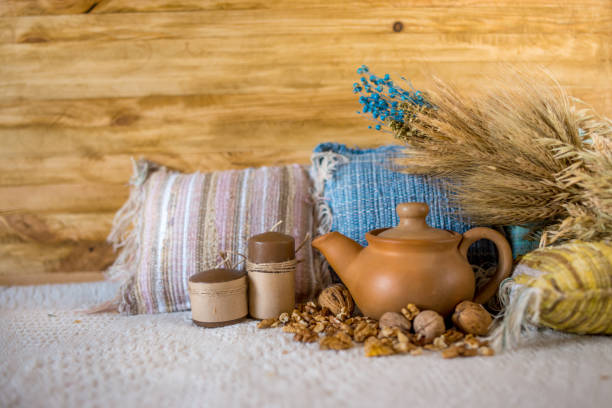 istock Clay teapot with wheat ear, pillow and nuts on the cloth background 843478804