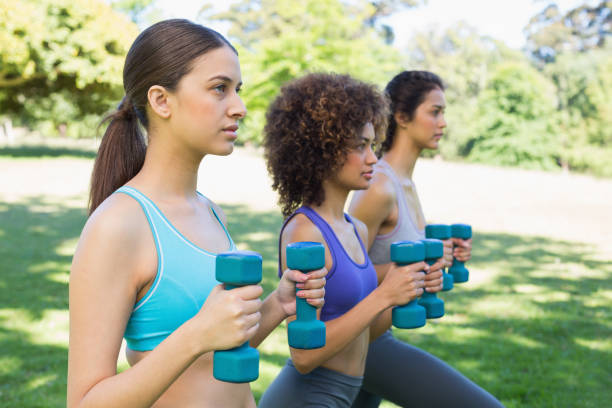 istock Sporty friends lifting dumbbells in park 843484144