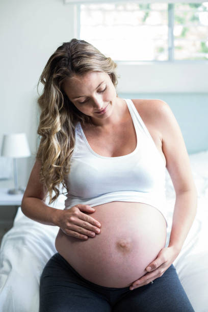 istock Pregnant woman massaging her belly 843484192