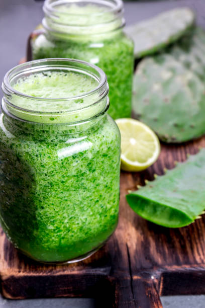 Cactus smoothie. Healthy nopales, aloe vera and lemon detox drink in jars and ingredients stock photo