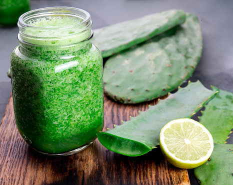 Cactus smoothie. Healthy nopales, aloe vera and lemon detox drink in jars and ingredients.
