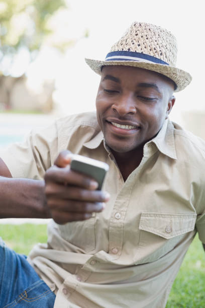 istock Smiling man relaxing in his garden texting on phone 843488200