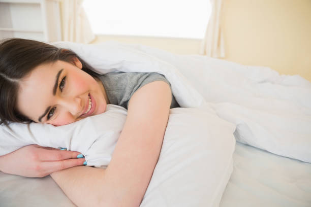 istock Happy brunette relaxing in her bed 843491624