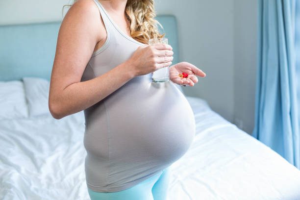 istock Pregnant woman taking a pill 843494844