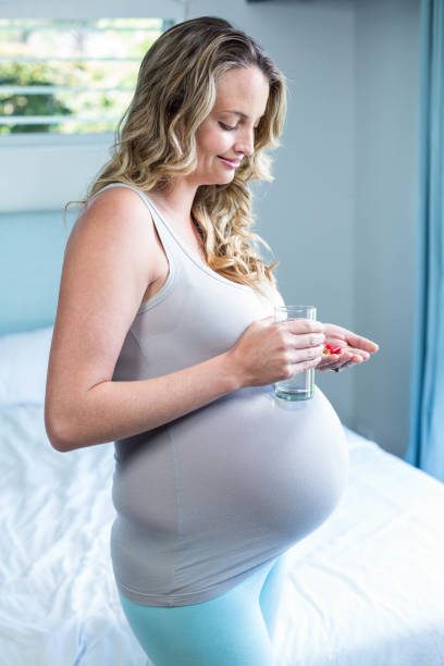 istock Pregnant woman taking a pill 843494850