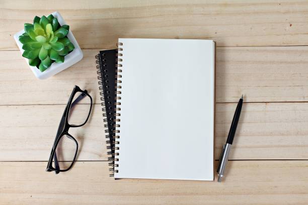 istock Office desk table with open notebook paper, pen and eyeglasses, Flat lay or top view with copy space, ready for adding or mock up 843498904