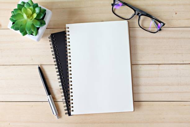 istock Office desk table with open notebook paper, pen and eyeglasses, Flat lay or top view with copy space, ready for adding or mock up 843499096