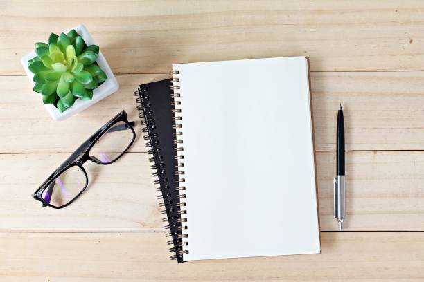 istock Office desk table with open notebook paper, pen and eyeglasses, Flat lay or top view with copy space, ready for adding or mock up 843499100