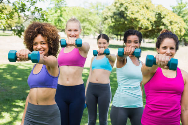 istock Women exercising with dumbbells in park 843499262